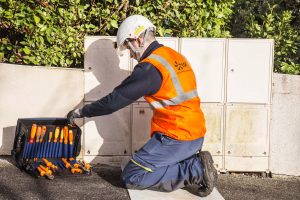 Technicien électricien range ses outils dans le grand rangement noir en bleu avec coque en polypropylène 